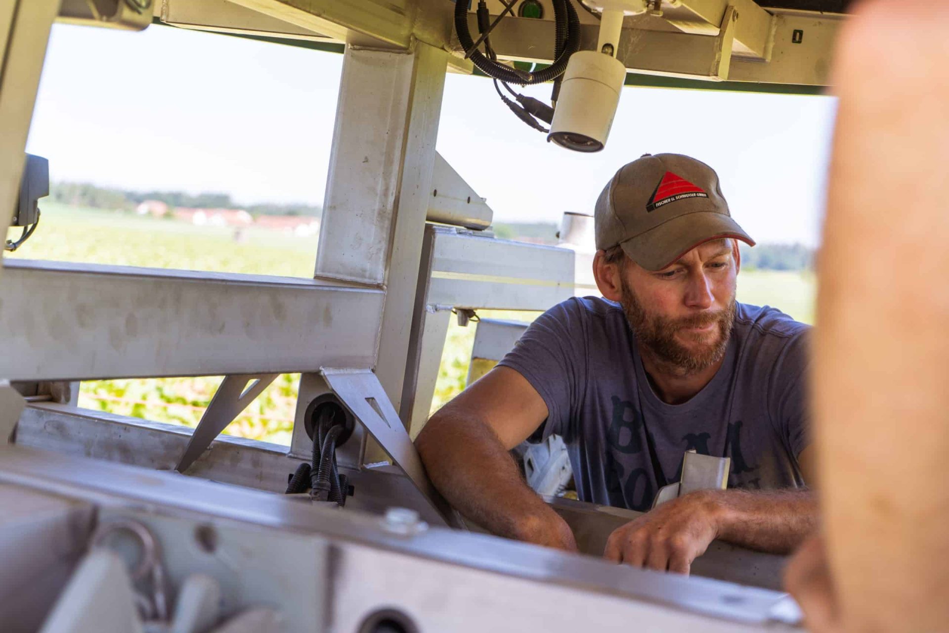 Ecological farmer sitting underneath the FarmDroid FD20 robot on a sugar beet field
