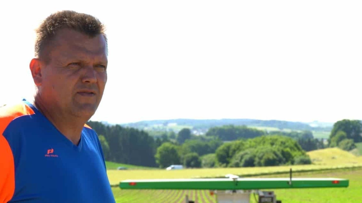 Parsley farmer standing in front of robot on his field