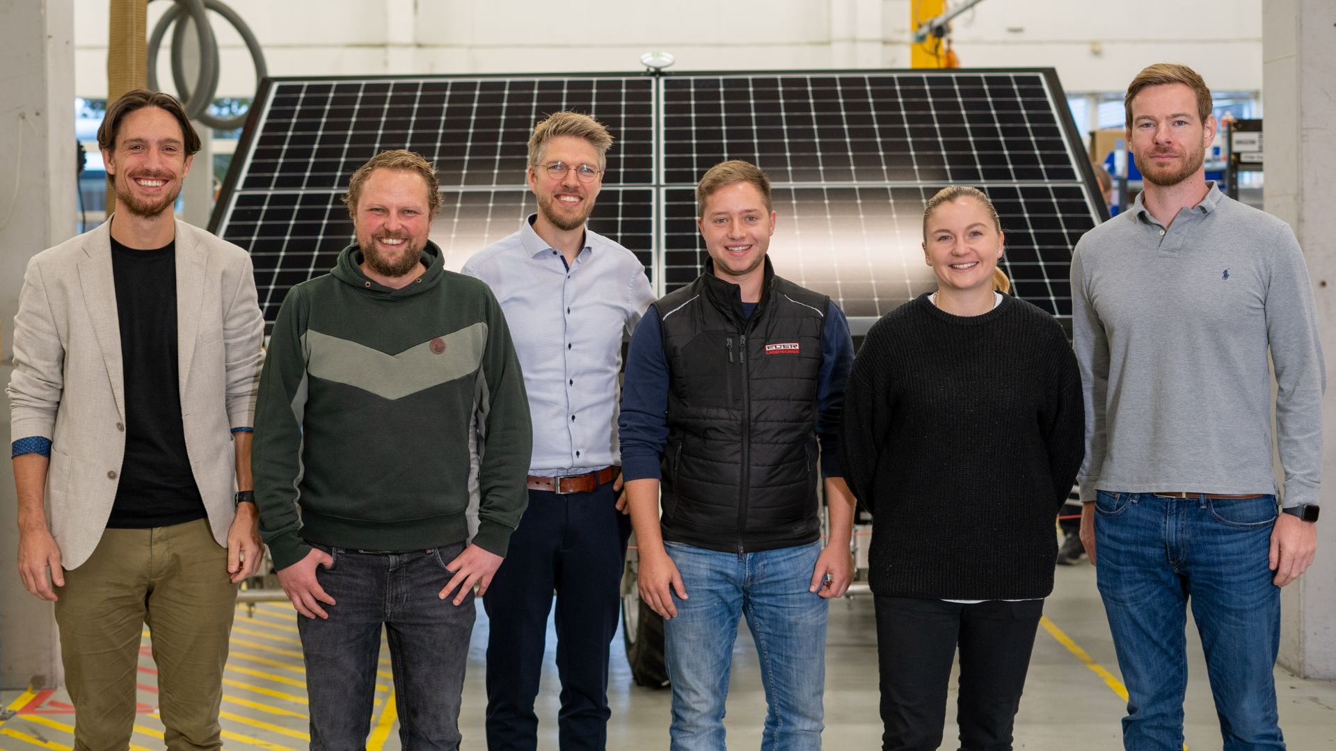 picture of Eder employees visiting FarmDroid standing in fron of a FarmDroid in production